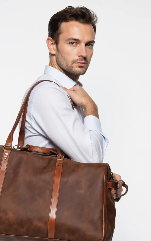 A French male model with a Travel bag, wearing a shirt, against a white background, in a front   facing close   up